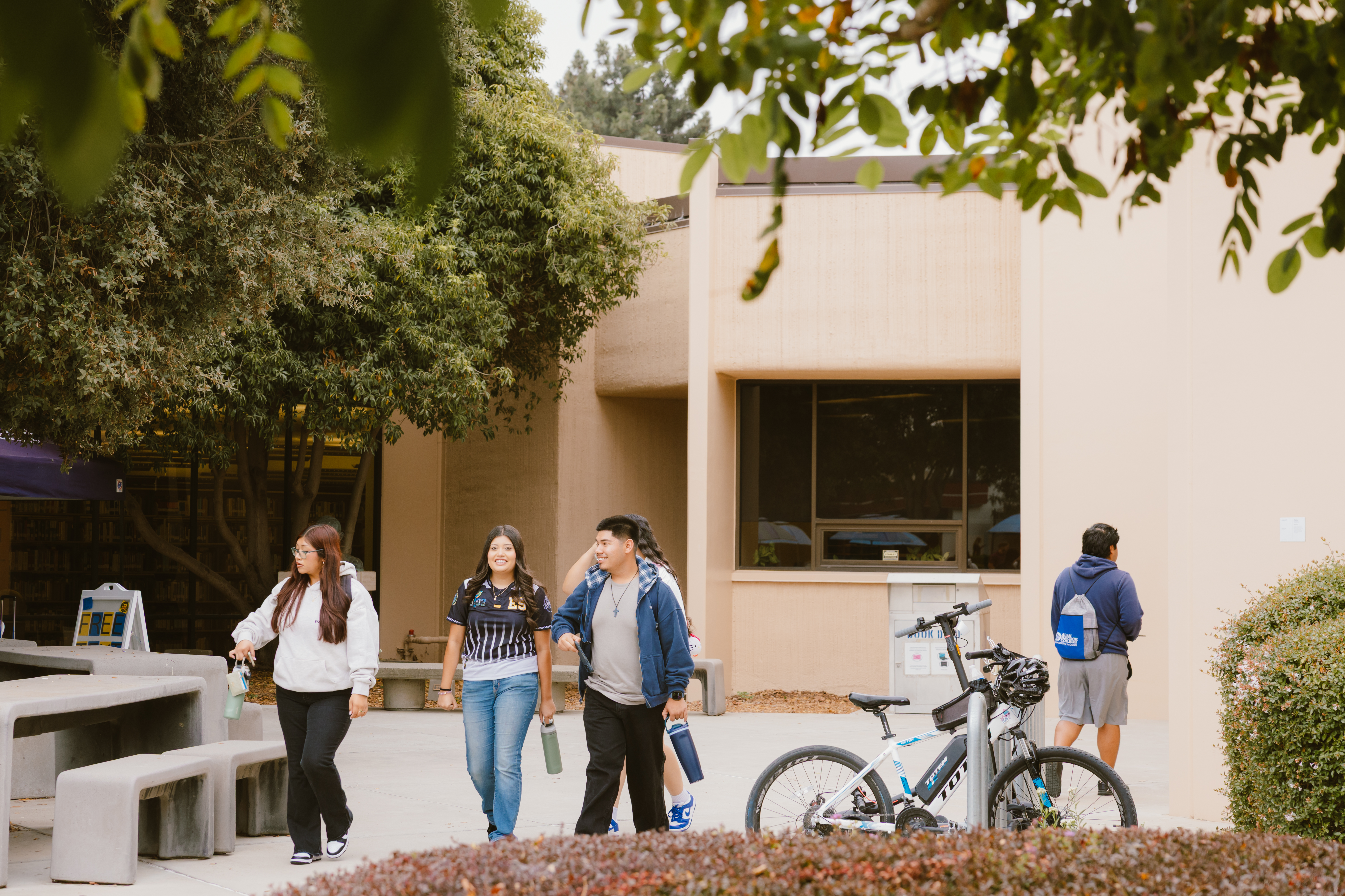 Students smile and wlak outside of the library at Allan Hancock College.